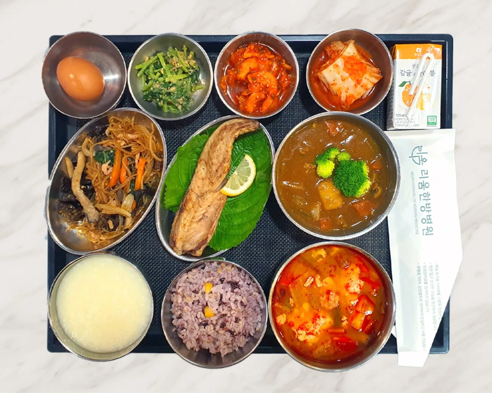 생선구이와 카레, 잡채·잡곡밥·김치찌개에 삶은 달걀과 주스를 곁들인 식판 · 리움한방병원 종로 식단
